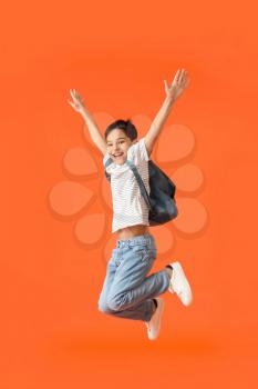 Jumping little schoolboy on color background�