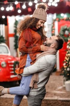 Happy young couple celebrating Christmas outdoors�