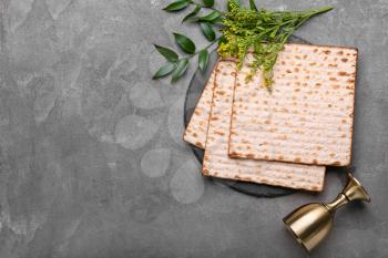 Jewish flatbread matza for Passover and cup on grey background�