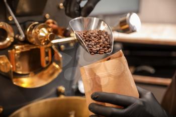 Man packaging coffee beans after roasting�