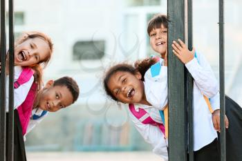 Cute little pupils near school entrance outdoors�