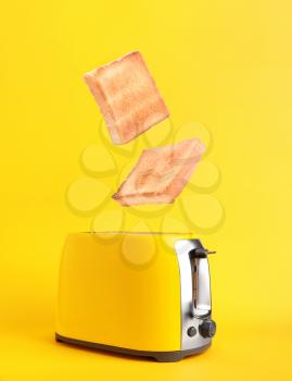 Toaster with bread slices on color background�