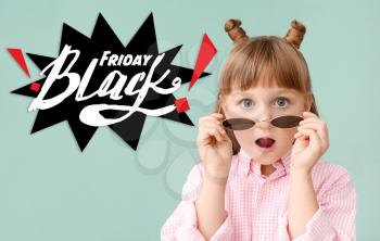 Surprised little girl and inscription BLACK FRIDAY on color background�