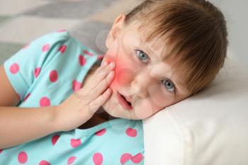 Little girl suffering from toothache at home�