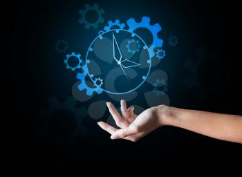 Hand of young woman with drawn clock on dark background�
