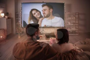 Young couple watching movie at home�
