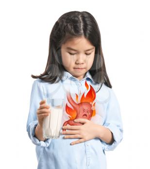 Little Asian girl drinking milk to relieve heartburn on white background�