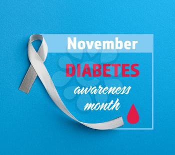 Awareness ribbon and text NOVEMBER DIABETES AWARENESS MONTH on blue background�