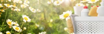 Set of cleaning supplies in chamomile field�