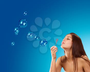 Royalty Free Photo of a Young Woman Blowing Soap Bubbles