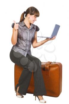 Royalty Free Photo of a Woman on a Suitcase With a Laptop Giving Thumbs Up