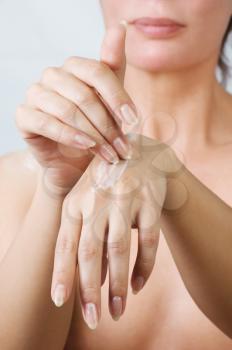 Woman hands applying moisturizing cream to her skin.Shallow focus