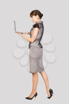  Beautiful businesswoman with laptop over light background 