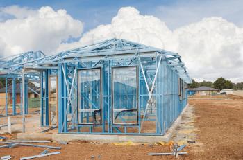 New home under construction using steel frames against cloudy sky