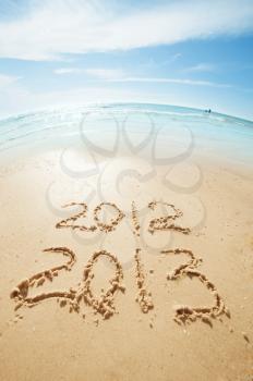 digits  2012 and 2013 on the sand seashore - concept of new year