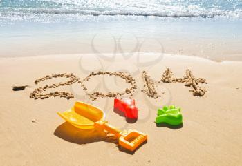 digits 2014 and toys on the sand seashore - concept of new year and vacation 