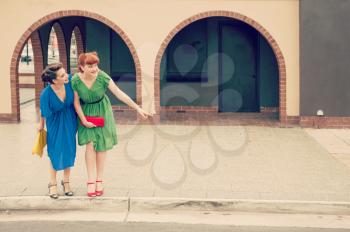 Two beautiful girls in retro style in the street