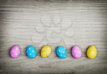 multicolored easter eggs on vintage wooden background