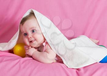 Adorable happy baby girl with white  towel on pink background 