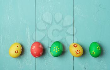 multicolored easter eggs on vintage painted wooden background with craquelure