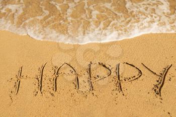 
Happy message on the beach sand - vacation and travel concept
