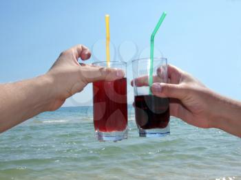 Royalty Free Photo of Drinks Being Raised in Front of an Ocean