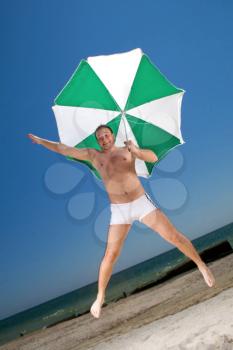 Royalty Free Photo of a Man on the Beach With an Umbrella