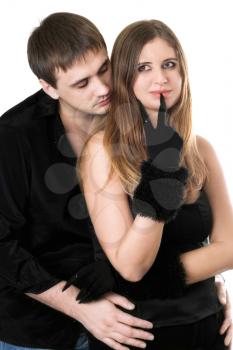 Royalty Free Photo of a Man Embracing a Woman With Her Finger at Her Lips