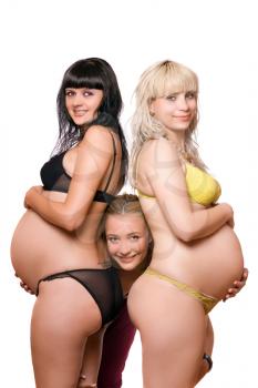 Royalty Free Photo of a Two Pregnant Women and Another Woman Looking Between Them