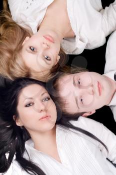 Royalty Free Photo of a Man and Two Women Lying With Their Heads Together 