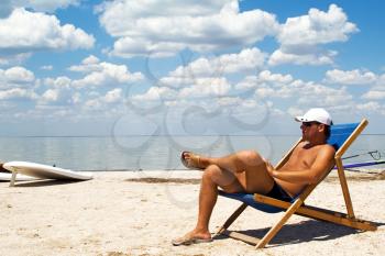 Royalty Free Photo of a Man on the Beach in a Chair