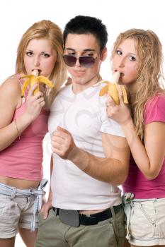 Royalty Free Photo of a Boy With Two Girls Eating Bananas