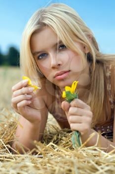 Royalty Free Photo of a Woman Lying in a Field Holding a Flower