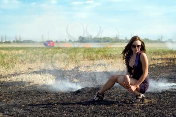 Royalty Free Photo of a Young Woman Crouched in a Field