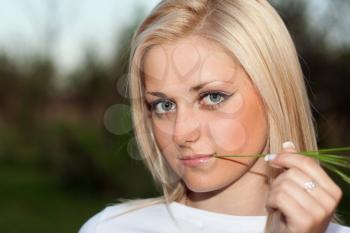 Royalty Free Photo of a Young Woman Chewing on a Sprig