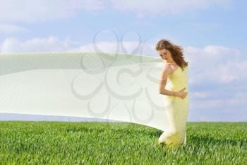 Young cute woman in a green field 