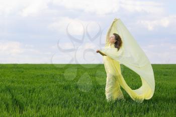 Lovely expressive young woman in a green field