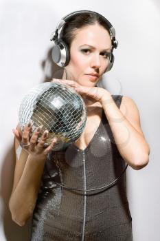 Portrait of beautiful brunette with a mirror ball in her hands