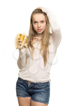 Young pretty woman holding banana and touching her blond hair. Isolated on white