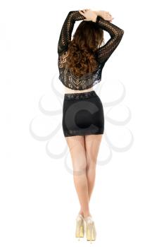 Slim brunette in black skirt and blouse posing back. Isolated on white