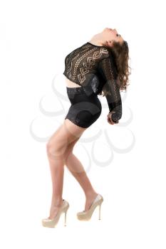 Sexy curly brunette posing in black clothing and beige shoes. Isolated on white