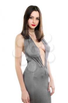 Pretty young brunette wearing grey dress with a plunging neckline. Isolated on white