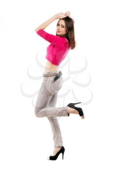 Elegant young lady posing in grey jeans, pink jacket and black shoes. Isolated on white