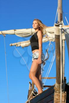 Pretty teen girl standing at stern of the ship