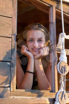 Girl in the window of an old wooden ship