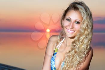 Portrait of smiling blond woman posing at the sunset