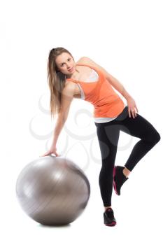 Young sporty woman posing with fit ball. Isolated on white