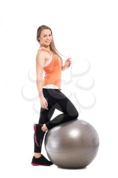 Young smiling woman posing with fit ball. Isolated on white