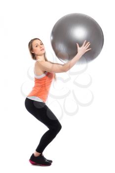 Young sporty woman holding fit ball. Isolated on white