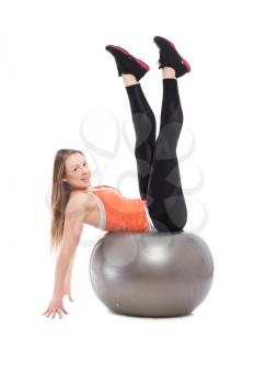Young woman doing exercises on a grey fit. Isolated